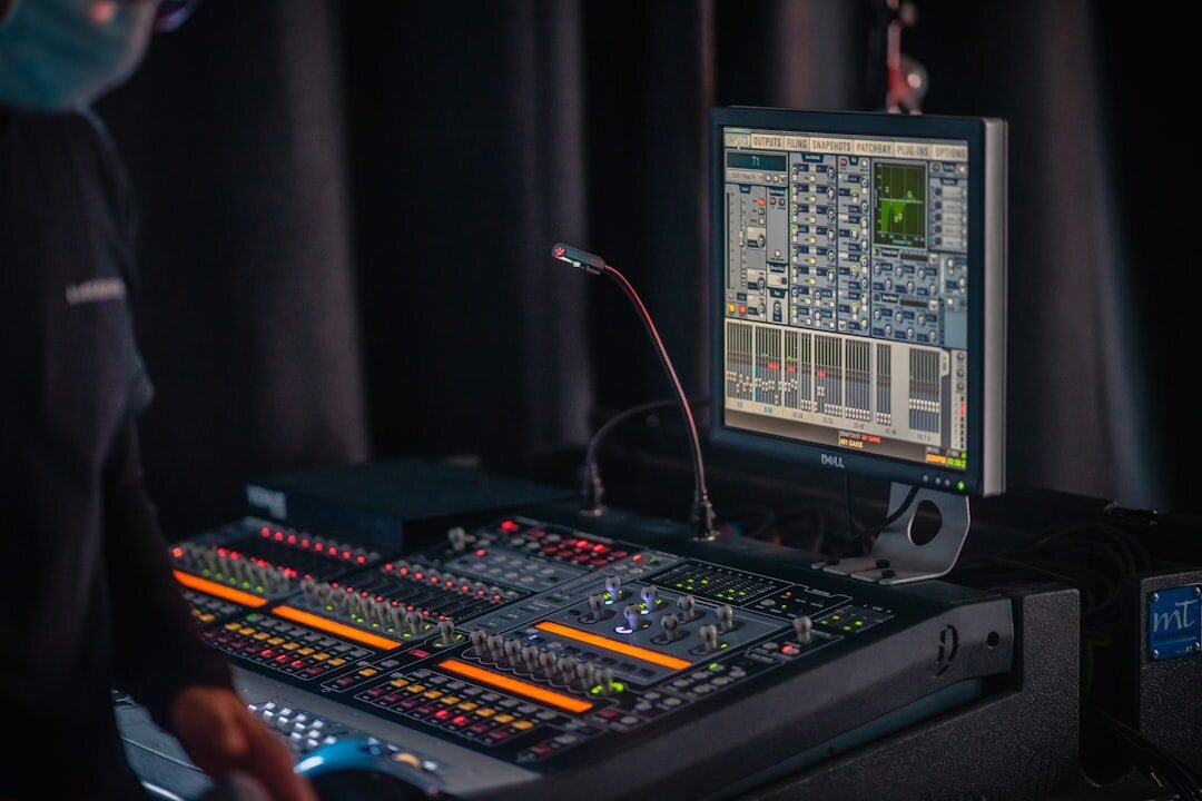 Video engineer operating a camera control unit while monitoring live broadcast feeds