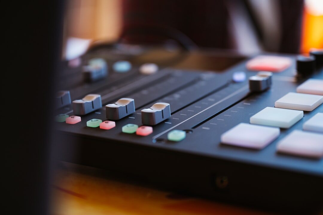 Close up of a video vision mixer switching panel with illuminated buttons and faders